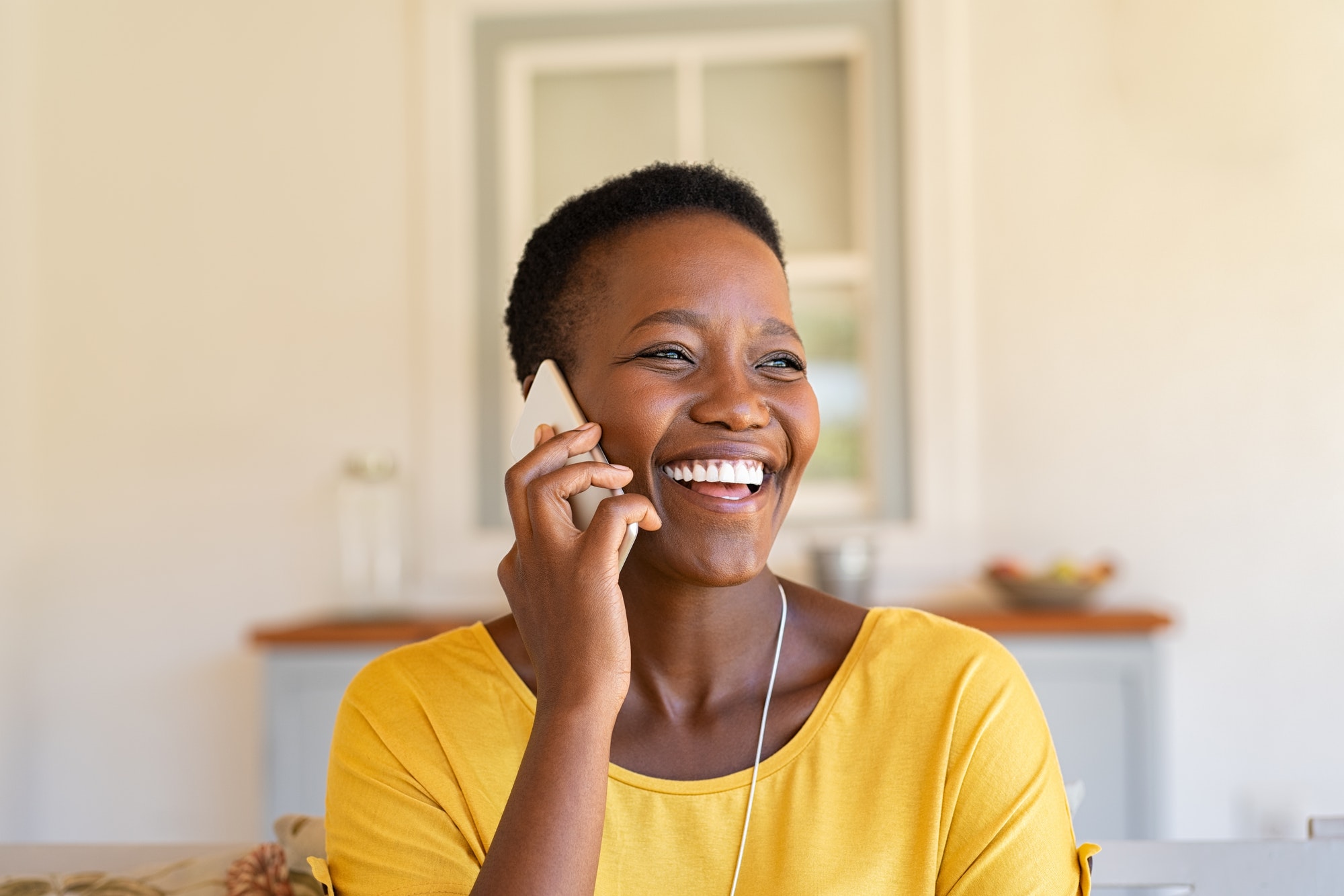 woman laughing while talking on phone